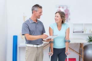 Woman using crutch and talking with her doctor